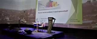 Een leeg podium met een PowerPoint presentatie op de achtergrond